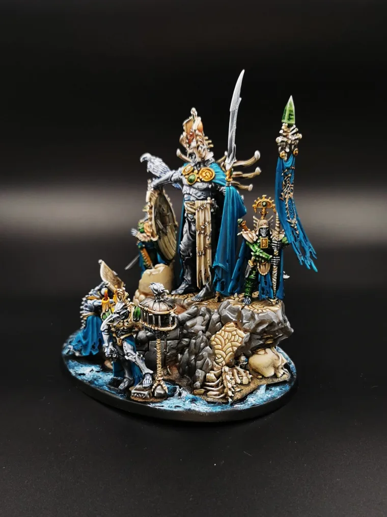 Groupe de figurines dorées et bleues sur un socle rocheux enneigé